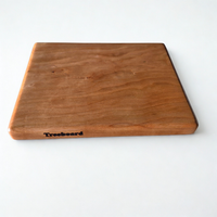 Small cherry cutting board by Treeboard. Elegant chopping board with a white background. The black cherry is a "gummy" or "heavy gum" cherry.