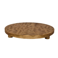 Round trivet seen from the side. A cherry stand for hot pans with three legs, by Treeboard. Photo shows curly cherry grain.