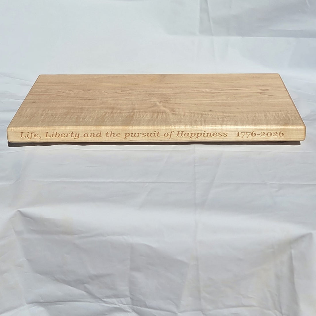 250th U.S.A. anniversary special maple cutting board by Treeboard with quotation from the Declaration of Independence: "Life, Liberty and the pursuit of Happiness." 1776-2026
