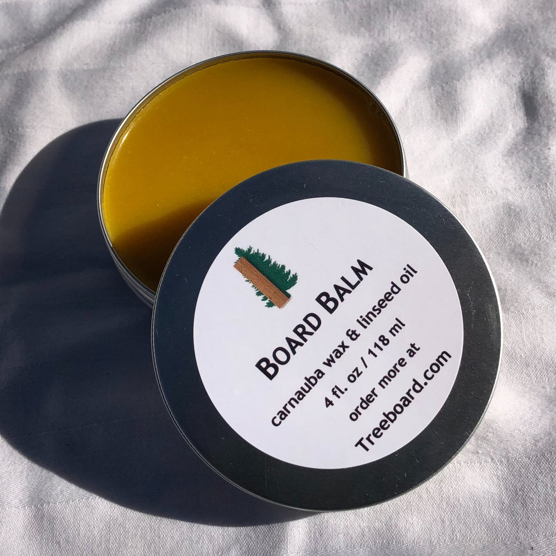 Board balm or wood wax by Treeboard, used for sealing moisture out of cutting boards, wooden spoons or for finishing any wooden surface. Some even use it for hand moisturizer or frizzy hair. The wax is made from carnauba wax and food-grade raw linseed oil, with no mineral oil or non-plant-based substances.