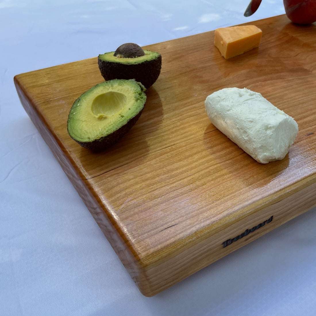 Large black cherry serving board and cutting board or cheese board by Treeboard with goat cheese, or chevre, avocado.