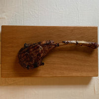 Large white oak cutting board by Treeboard with a tomahawk steak.
