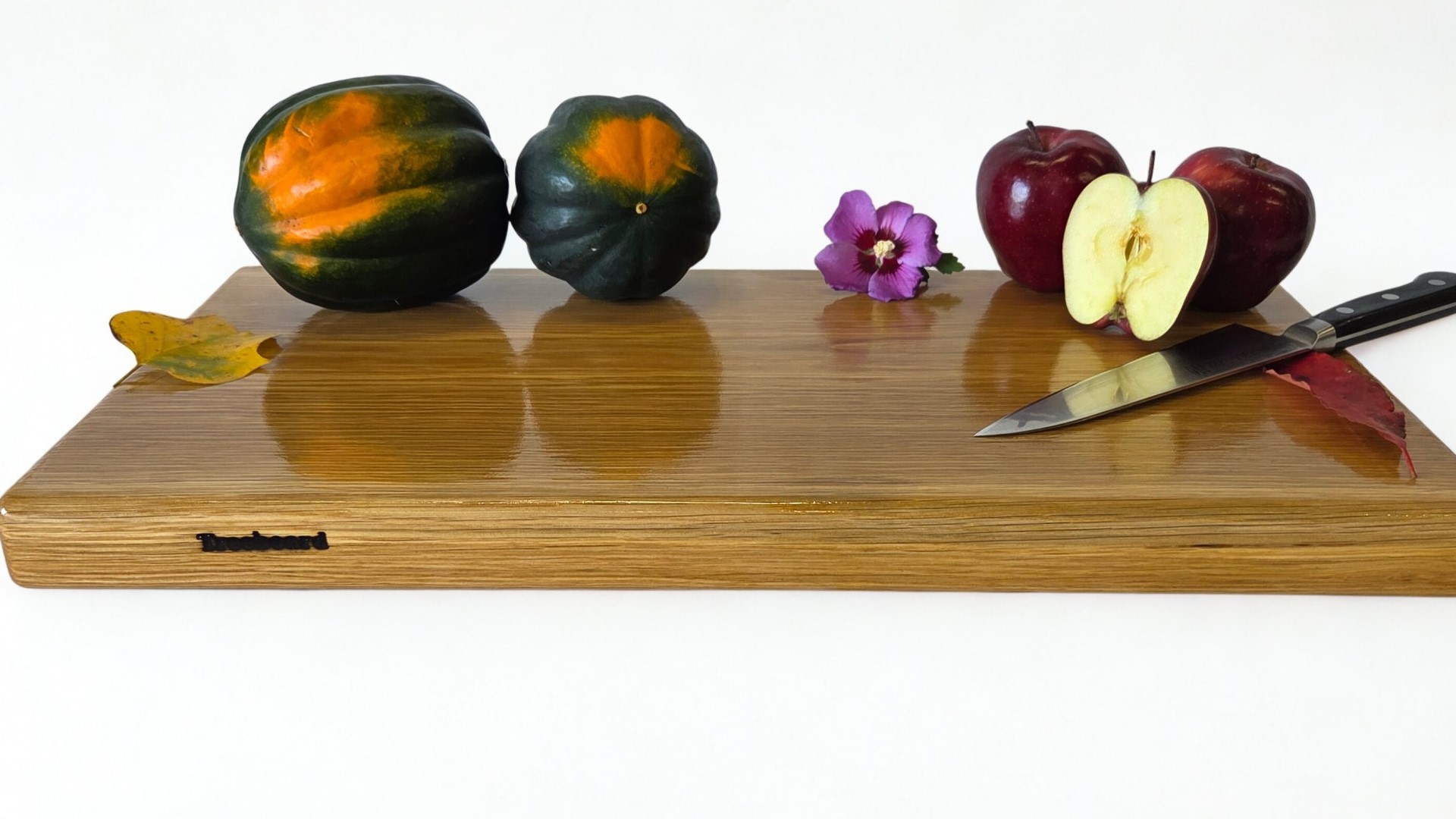 Apple and squash and knife on an oak cutting board by Treeboard