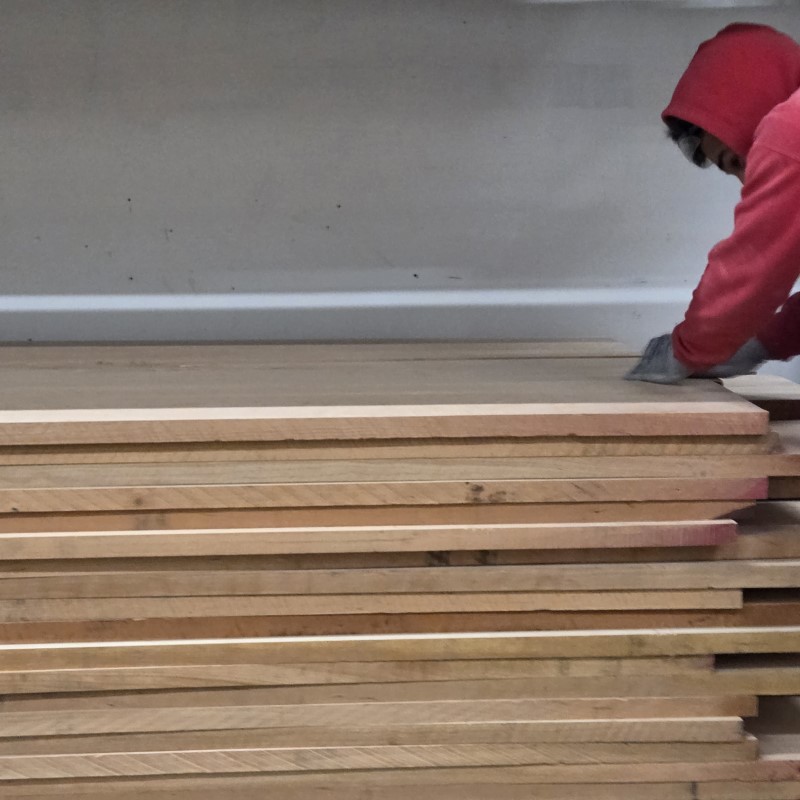 Worker stacking cherry lumber at Treeboard.