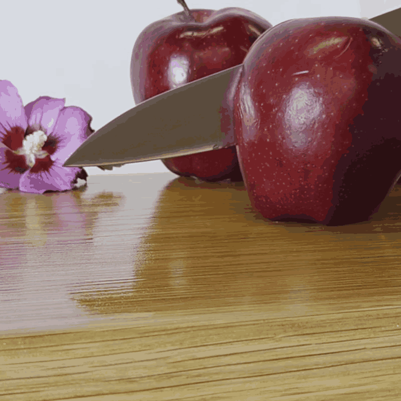 Knife slicing an apple on a Treeboard oak cutting board